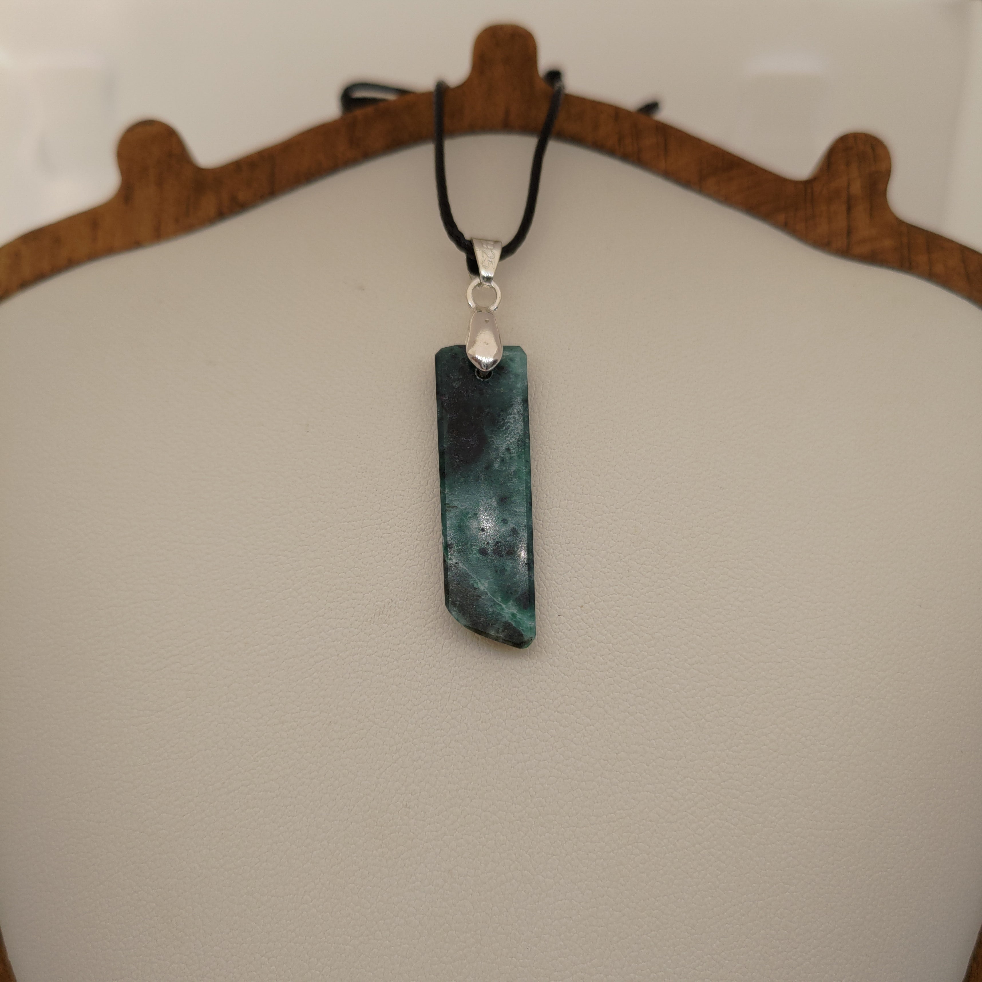 Necklace with a green stone pendant on a neutral background
